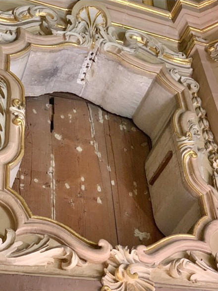 Wooden planks screening the stone wall behind a niche which usually holds a painting. Curia Church, Floriana, Malta. Photo by Valentina Lupo.